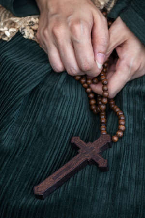 female hands holding a large wooden ocrossの写真素材