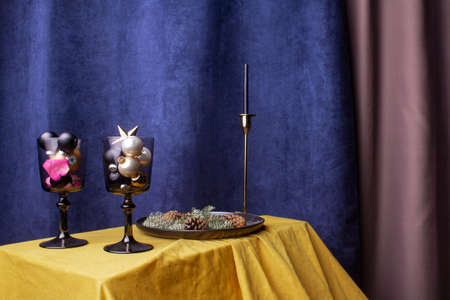 spruce branch on a black plate, Christmas toys. Concept for a luxurious New Year photo, against a background with colored fabricsの写真素材