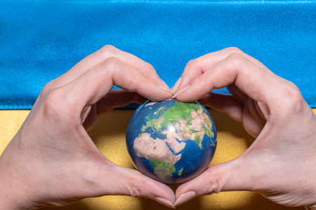 The flag of Ukraine is yellow and blue, and the hand holds the globe. Martial law in Ukraine. Stop...