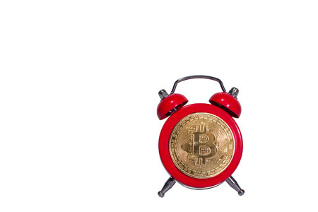 Bitcoin and alarm clock on black background. Deadline concept for investing in bitcoin cryptocurrency.の写真素材