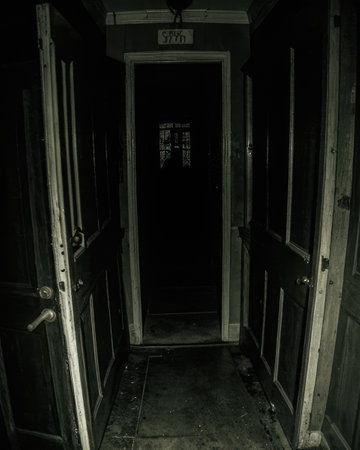 Old wooden door in a dark room. Black and white photo.の素材