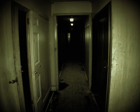 Dark corridor with old door and light at the end of it.の素材