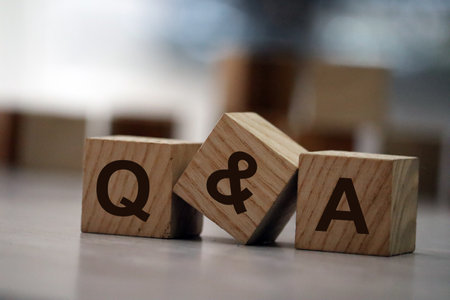 Q and A - an abbreviation of wooden blocks with letters on a gray background. Reflection of the Q and A caption on the mirrored surface of the table. Selective focus.の写真素材