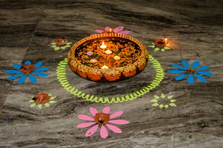 Happy Diwali - rangoli painting on floor for diwali with floating candlesの写真素材