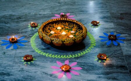Happy Diwali - rangoli painting on floor for diwali with floating candlesの写真素材