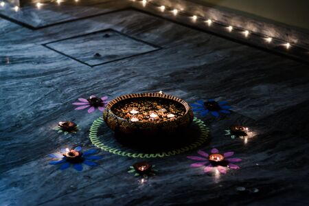 Happy Diwali - rangoli painting on floor for diwali with floating candlesの写真素材