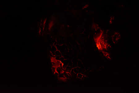 Burning and glowing charcoal close-up. Red coals with fire on a black background. Burning coals.の写真素材