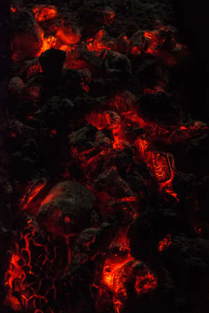 Burning and glowing charcoal close-up. Red coals with fire on a black background. Burning coals.