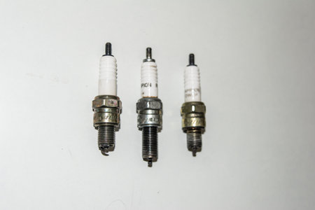 Spark plug for cars and bike on an isolated white background. Copper spark plugs. Spark plugs with...
