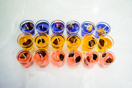 Gel candle in glass isolated on white background. set of colored gel candles. Candle in glass with many colored candles.の写真素材
