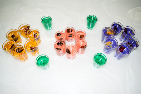Gel candle in glass isolated on white background. set of colored gel candles. Candle in glass with many colored candles.の写真素材