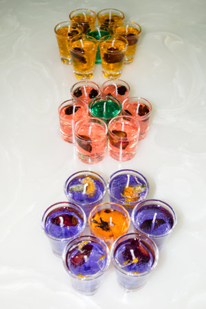 Gel candle in glass isolated on white background. set of colored gel candles. Candle in glass with many colored candles.の写真素材