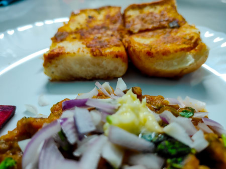 Mumbai Style Pav Bhaji, Indian spicy fast food with bread, onion and butter. Pav bhaji is a fast food dish from India consisting of a thick vegetable curry served with a soft bread rollの写真素材