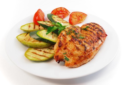 dish is chicken steak with vegetables on white backgroundの写真素材
