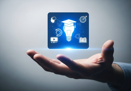 A palm opens to display a glowing blue square containing icons for learning, a lightbulb for ideas, and a graduation cap, symbolizing educational advancement.の素材