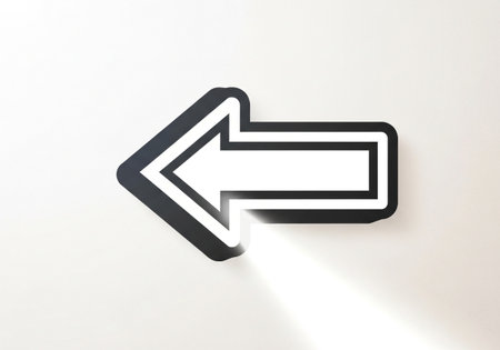 A bold black arrow, sharply defined with a white outline, indicates a leftward direction, casting a subtle shadow on the pure white surface it rests upon.の素材