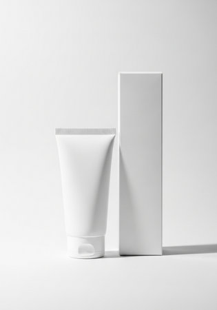A clean and minimalist presentation of a white cosmetic tube next to its matching packaging box, perfect for showcasing beauty products on a pure white background.の素材