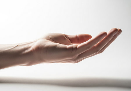 A close-up view of a person's left hand, palm open and facing skyward, fingers slightly curled, suggesting an act of offering or receiving something.の素材