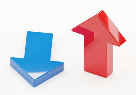 Two three-dimensional arrows, one red pointing up and one blue pointing down, are placed side-by-side on a white background, representing opposing directions or trends.の素材