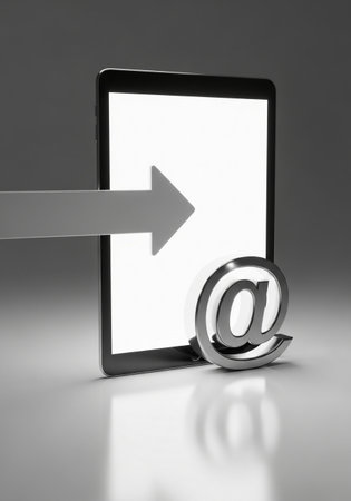 A modern tablet displays a bright, blank screen. A silver 'at' symbol rests at its base, while a grey arrow points towards the screen.の素材