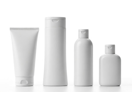 Four assorted white containers, including bottles and tubes, commonly used for personal care products like lotions and shampoos, presented cleanly.の素材