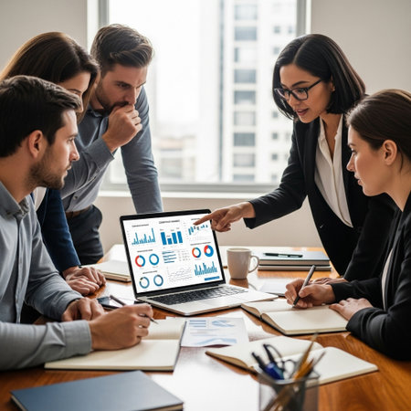 A group of professionals are gathered around a laptop displaying financial charts and graphs, engaged in a discussion.の素材