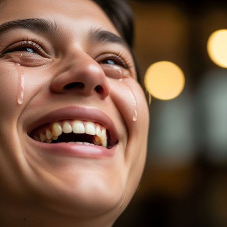 A close-up shot of a person laughing with tears of joy streaming down their cheeks, with bokeh lights in the background.の素材