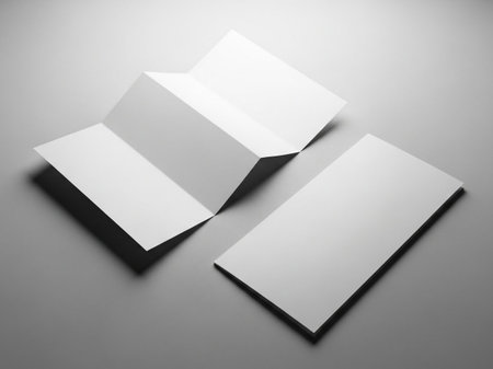 Three white business cards on gray background, one folded, with shadows and subtle gradient lighting effectsの素材