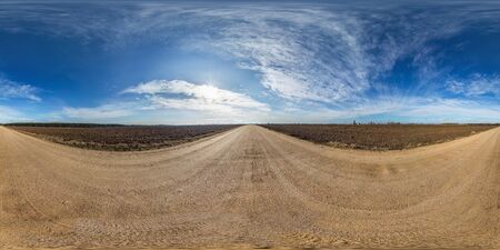 full seamless spherical panorama 360 degrees angle view on gravel road among fields in spring day with awesome clouds in equirectangular projection, ready for VR AR virtual reality contentの写真素材