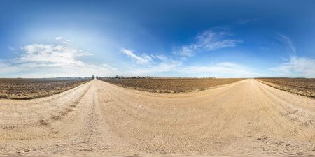 full seamless spherical panorama 360 degrees angle view on gravel road among fields in spring day with awesome clouds in equirectangular projection, ready for VR AR virtual reality contentの写真素材