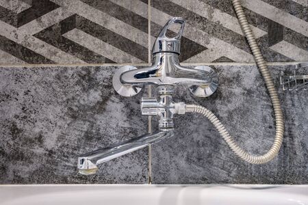 water tap sink with faucet in expensive loft bathroom. detail of a corner shower cabin with wall...