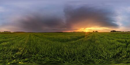 full spherical hdr panorama 360 degrees angle view among fields in summer evening sunset with beautiful clouds before storm in equirectangular projection, ready for VR AR virtual realityの写真素材