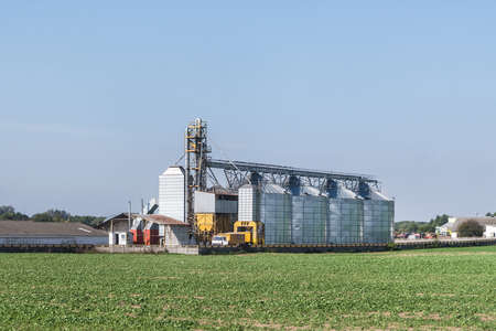 Modern Granary elevator with silver silos on agro-processing and manufacturing plant for processing...