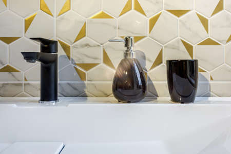 Ceramic Water tap sink with faucet with soap and shampoo dispensers in expensive loft bathroom or...