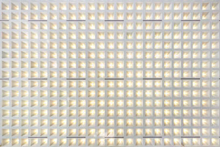rhythmic texture on suspended ceiling with rows of halogen spots lamps and drywall construction with...