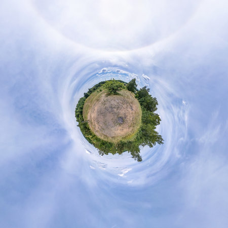 tiny planet in blue sky with sun and beautiful clouds. Transformation of spherical panorama 360...