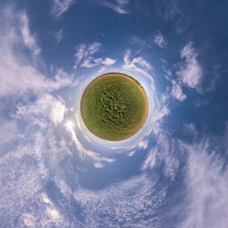 tiny planet in blue sky with sun and beautiful clouds. Transformation of spherical panorama 360...