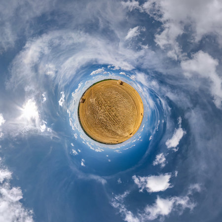 green tiny planet in blue sky with sun and beautiful clouds. Transformation of spherical panorama...