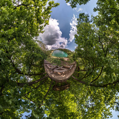 green tiny planet transformation of spherical panorama 360 degrees. Spherical abstract aerial view on forest. Curvature of space.の写真素材