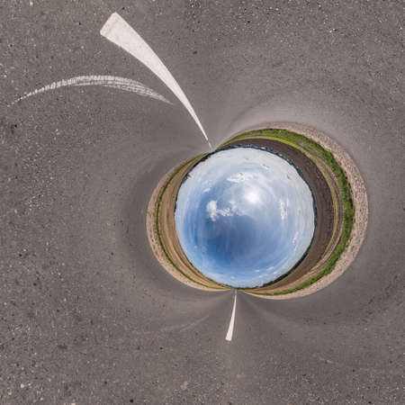 blue sky ball in middle of swirling asphalt road. Inversion of tiny planet transformation of...