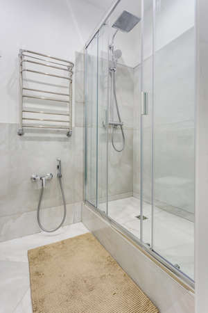 details of corner shower cabin with wall mount shower attachment and water tap sink with faucet in expensive bathroomの写真素材