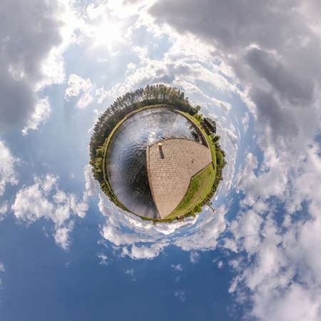 tiny planet in blue sky with sun and beautiful clouds. Transformation of spherical panorama 360...