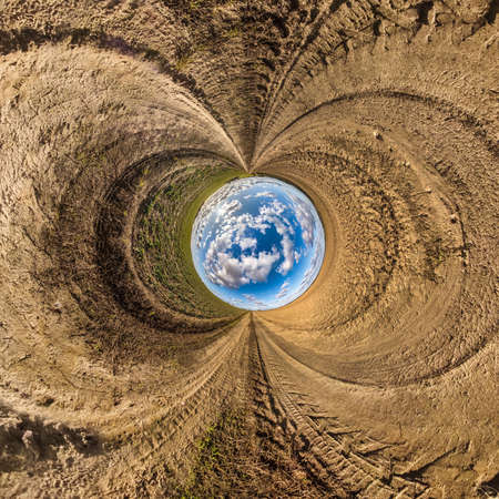 blue sky ball in middle of swirling asphalt road or field. Inversion of tiny planet transformation...
