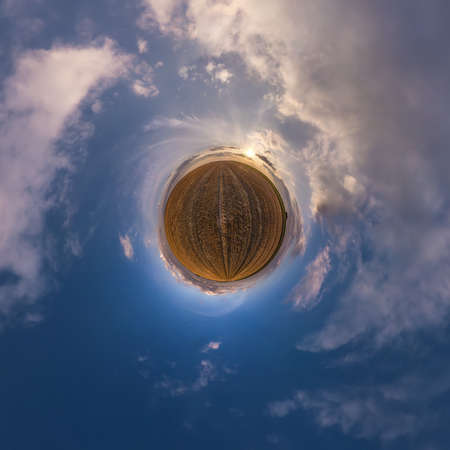 tiny planet in blue sky with beautiful clouds. Transformation of spherical panorama 360 degrees....