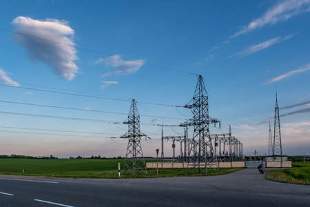Silhouette of the high voltage electric pylon towers on the background of beautiful evening clouds