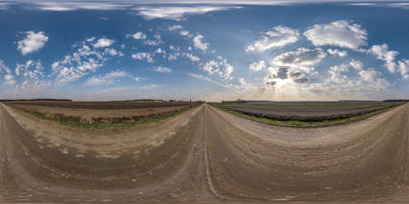 no traffic white sand gravel road among fields with cloudy sky in equirectangular projection, VR AR...