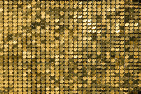 rows of blinking golden yellow brass metal plaques sway in wind and shines in sun and create unique...