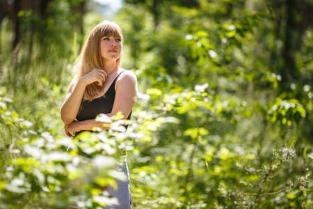 beautiful girl stands in thicket of forest