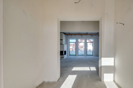 Empty unfurnished room with minimal preparatory repairs. interior with white walls and drywallの写真素材