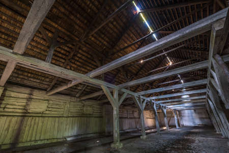 inside dark abandoned ruined wooden decaying hangar with rotting columnsの写真素材